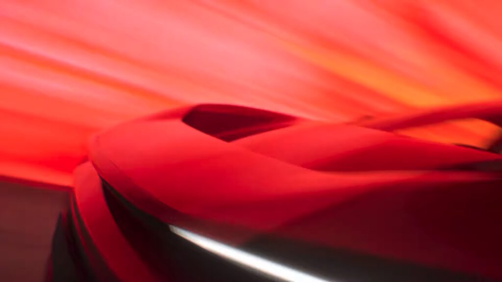 Rear view of the electric SUV coupe highlighting the infinity taillight bar and roof-integrated spoiler.