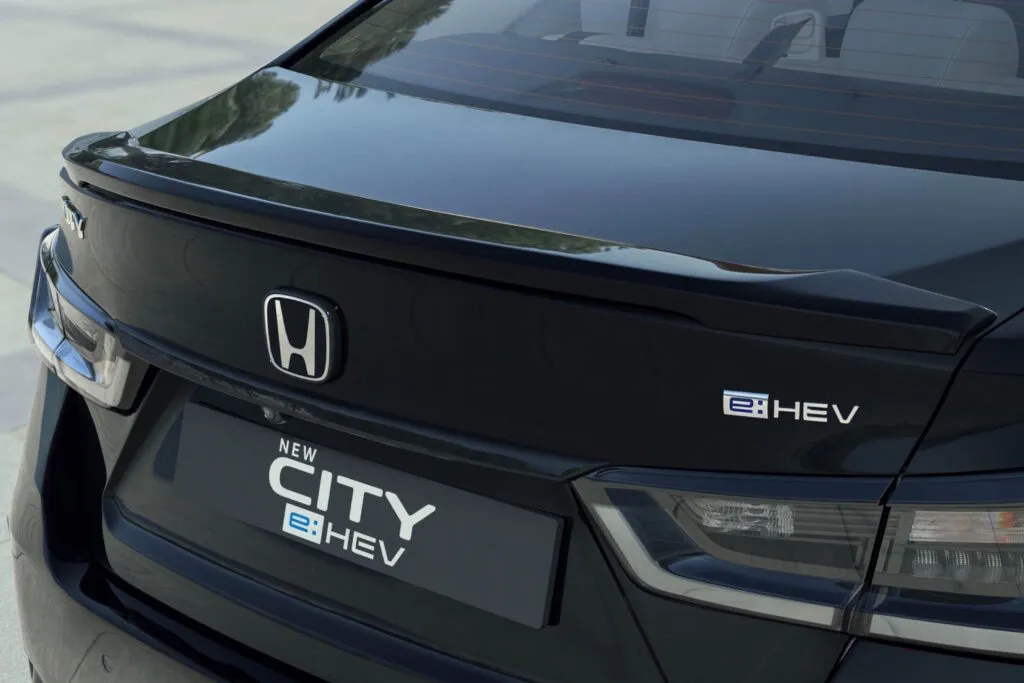 Rear view of a black Honda City e:HEV showing the trunk spoiler and hybrid badging